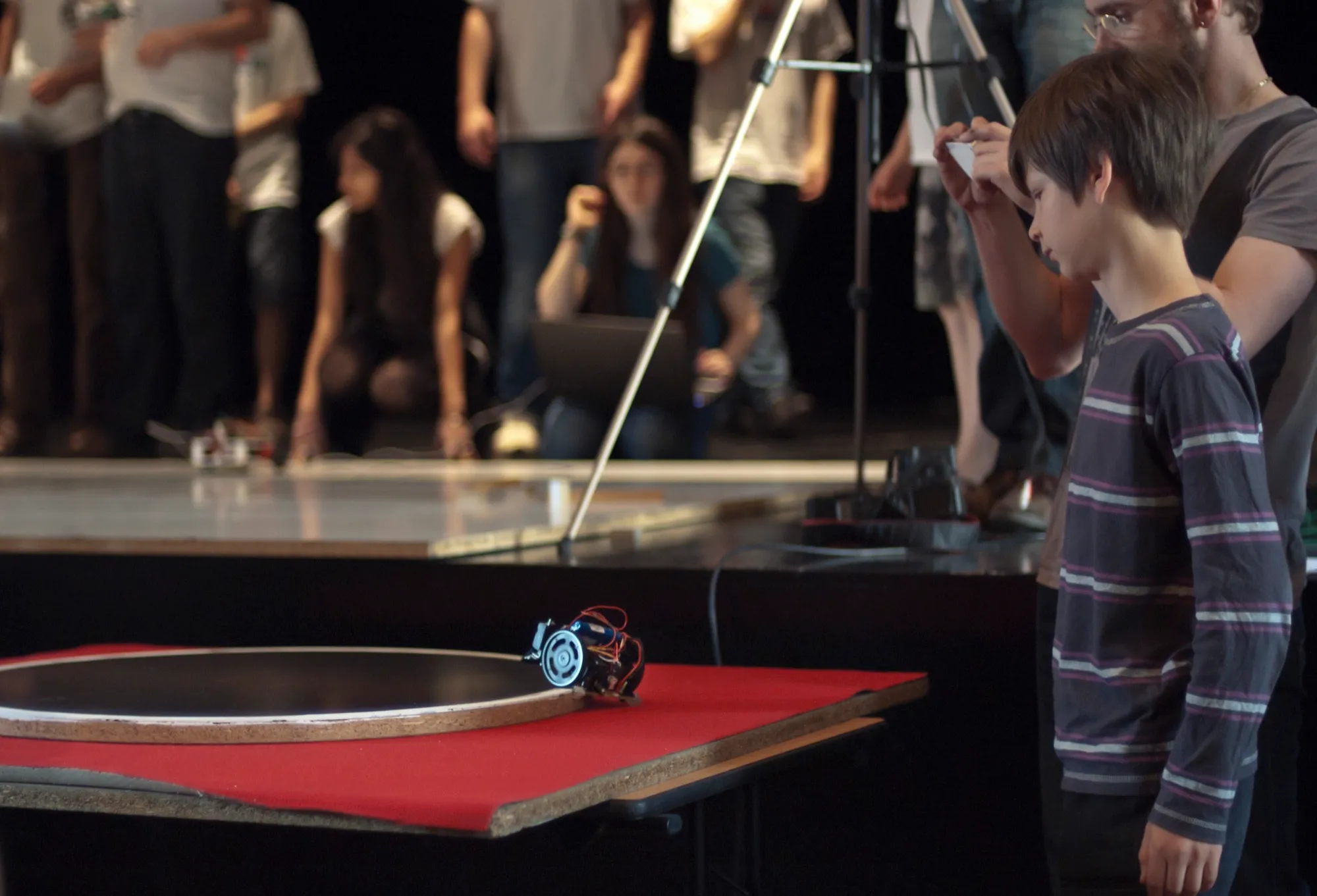 Robot sumo sur le dohyo au tournoi de Nîmes 2012, devant les jeunes pilotes